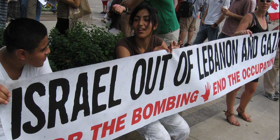 "Israel out of Lebanon and Gaza. Stop the bombing. End the occupation" lukee nuorten pitämässä banderollissa.