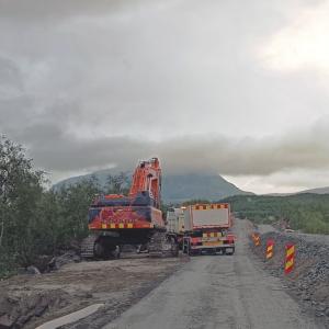 Kuvassa kaivuri ja kuorma-auto kunnostettavalla tiellä Saanatunturin edessä Kilpisjärvellä.