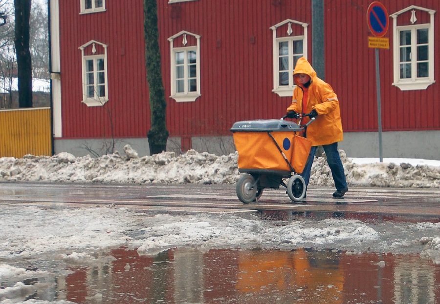 Postinjakaja työntää orasseja postikärryjä.