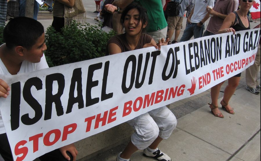 "Israel out of Lebanon and Gaza. Stop the bombing. End the occupation" lukee nuorten pitämässä banderollissa.