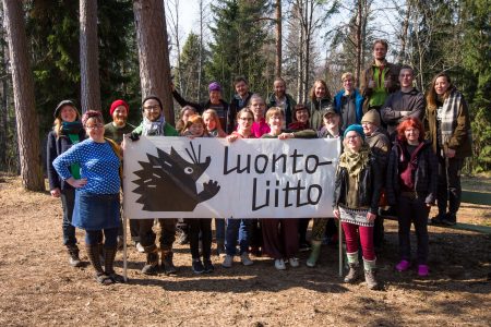 Luontoliiton jäsenet seisovat banderollin takana