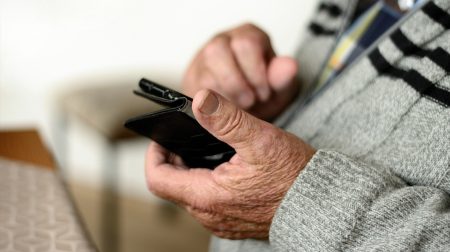 Matkapuhelin kädessä kuvituskuva