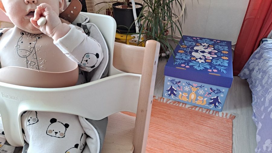 Kuvituskuva vauva syö puuroa taustalla Kelan vuoden 2024 äitiyspakkaus. Kuva Petra Packalén